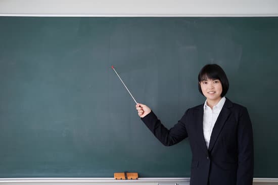 canva-japanese-female-teacher-points-to-the-blackboard-in-the-classroom-MAENwnar1Bs