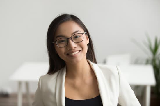 Smiling asian woman in glasses looking at camera, headshot portrait